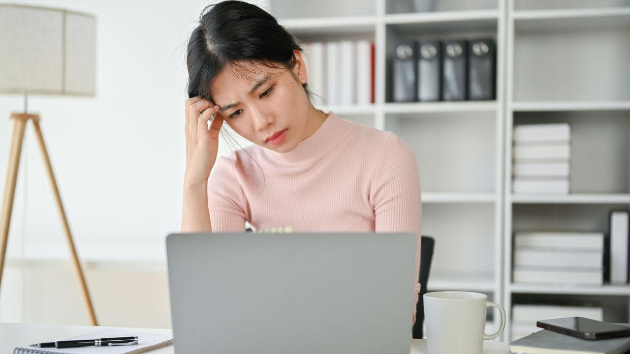 Chica preocupada seria mirando ordenador Chica preocupada seria mirando ordenador