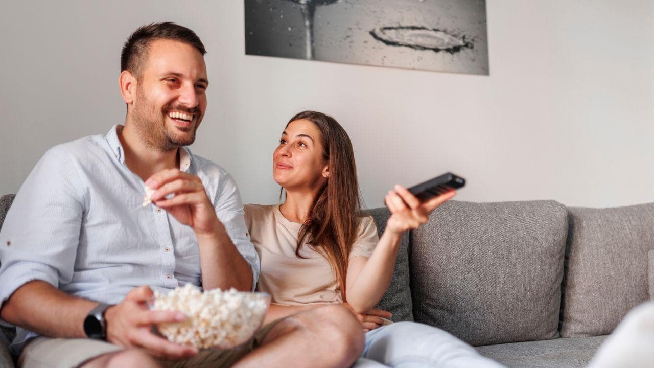 Pareja viendo TDT palomitas feliz Pareja viendo TDT palomitas feliz