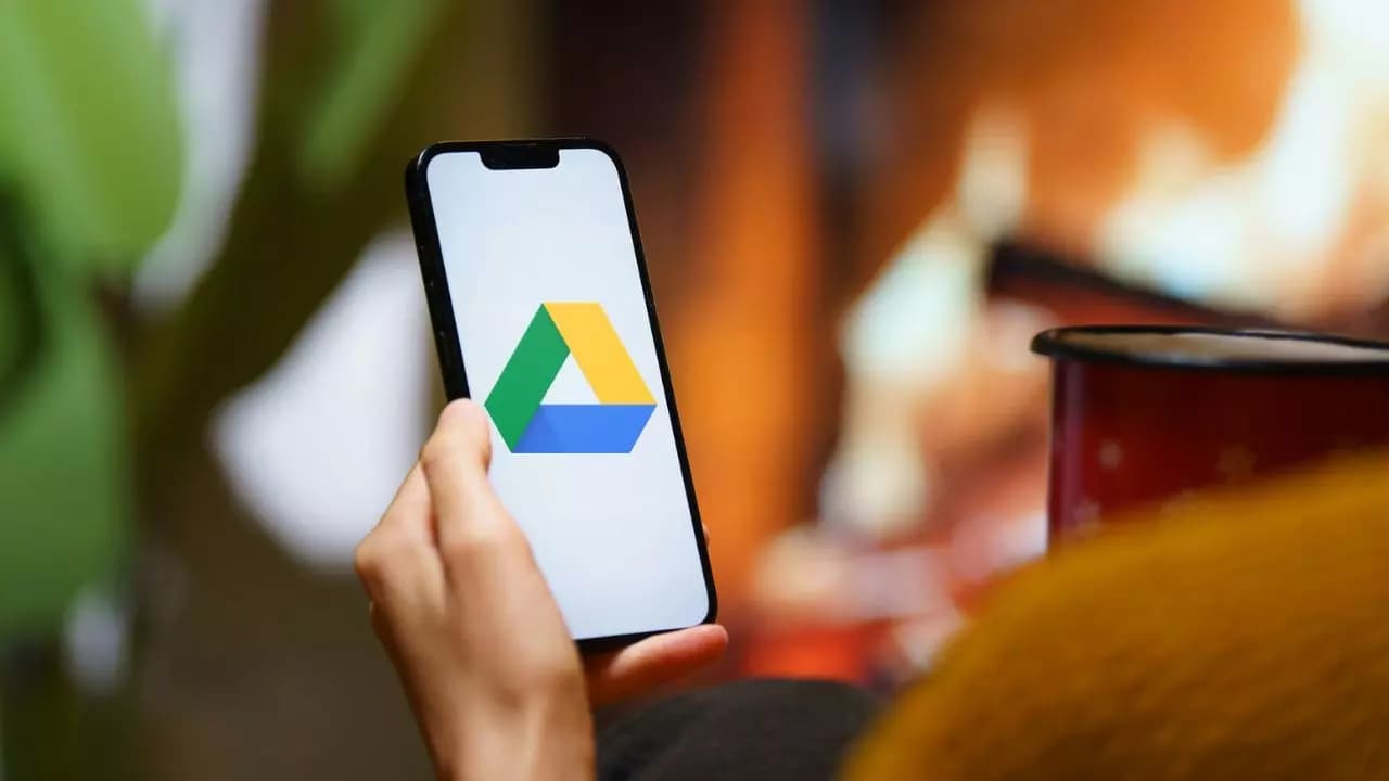 Sujetando movil pantalla logo Google Drive Sujetando movil pantalla logo Google Drive