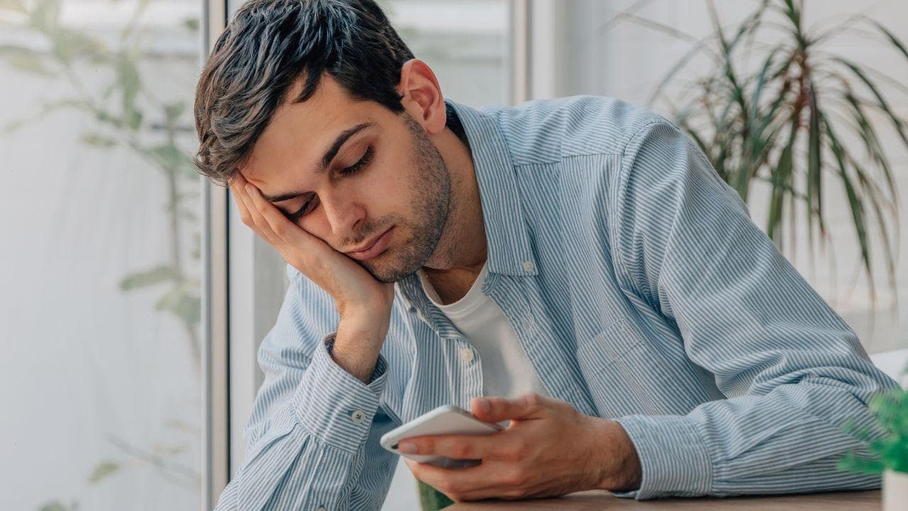 Chico mirando triste telefono movil Chico mirando triste telefono movil