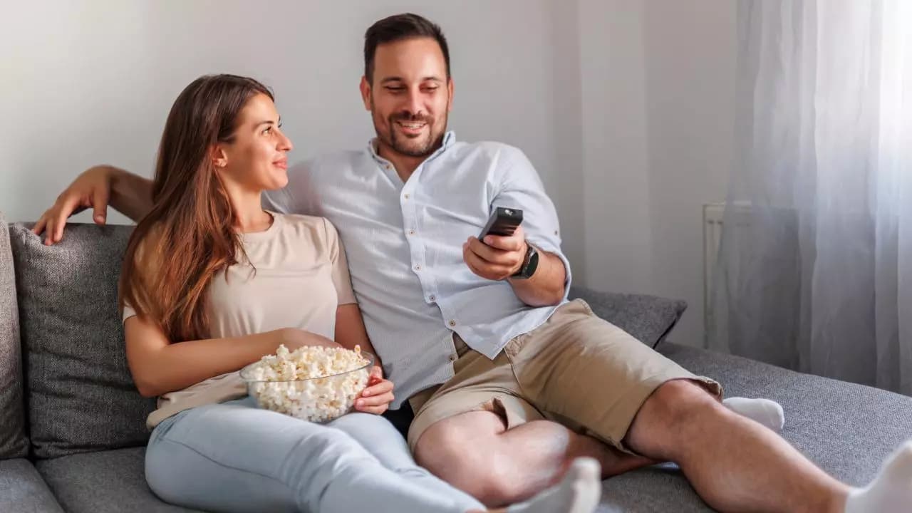 Pareja enamorada viendo tele mando Pareja enamorada viendo tele mando