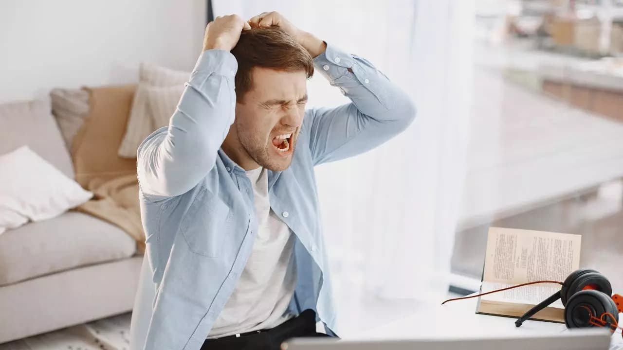 Chico enfadado manos cabeza gritando portatil Chico enfadado manos cabeza gritando portatil