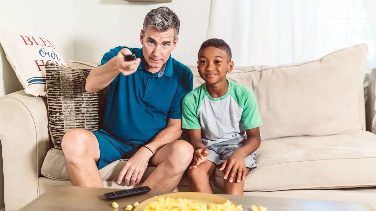 Padre hijo contentos viendo TV palomitas Padre hijo contentos viendo TV palomitas
