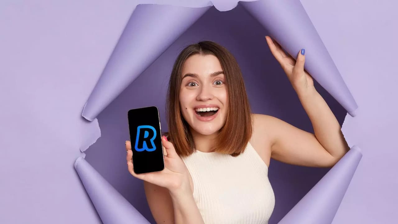 Chica saliendo pared sorprendiendo movil Revolut Chica saliendo pared sorprendiendo movil Revolut