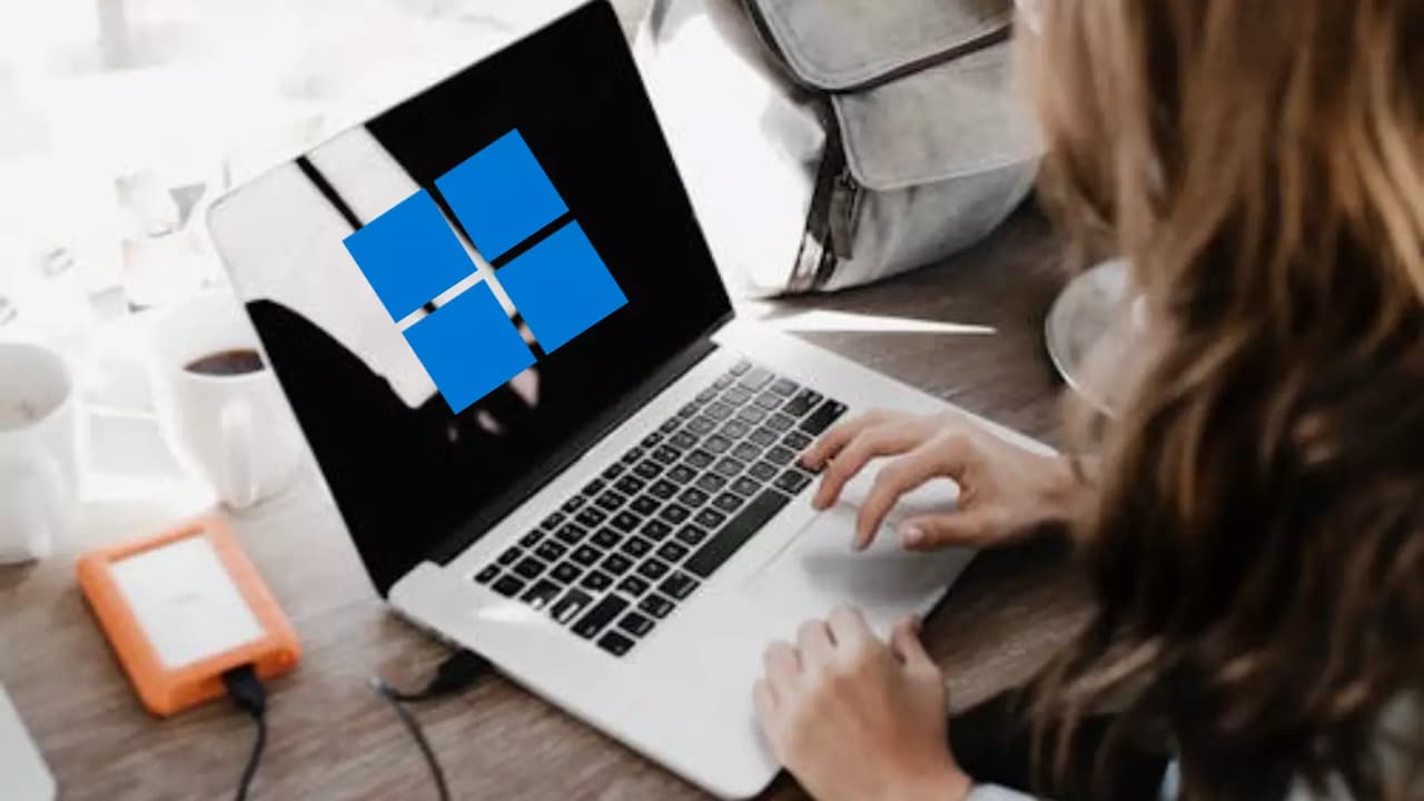 mujer-usando-ordenador-portatil-con-logo-Windows mujer-usando-ordenador-portatil-con-logo-Windows