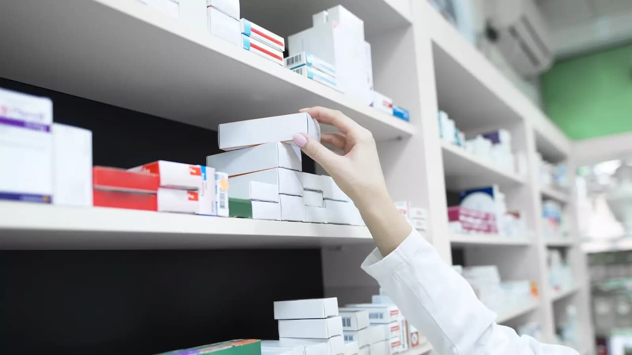 vista-de-cerca-de-la-mano-del-farmaceutico-tomando-la-caja-de-la-medicina-del-estante-en-la-farmacia vista-de-cerca-de-la-mano-del-farmaceutico-tomando-la-caja-de-la-medicina-del-estante-en-la-farmacia