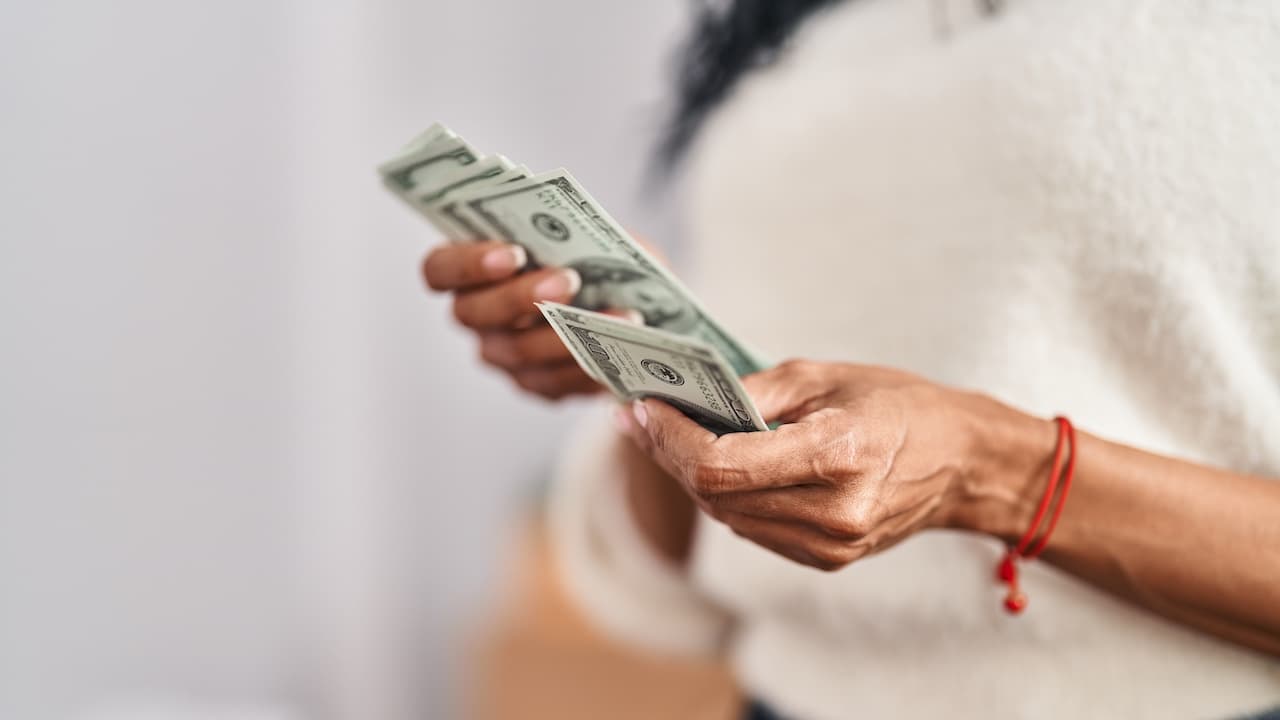 mujer-afroamericana-contando-dolares-en-su-nueva-casa